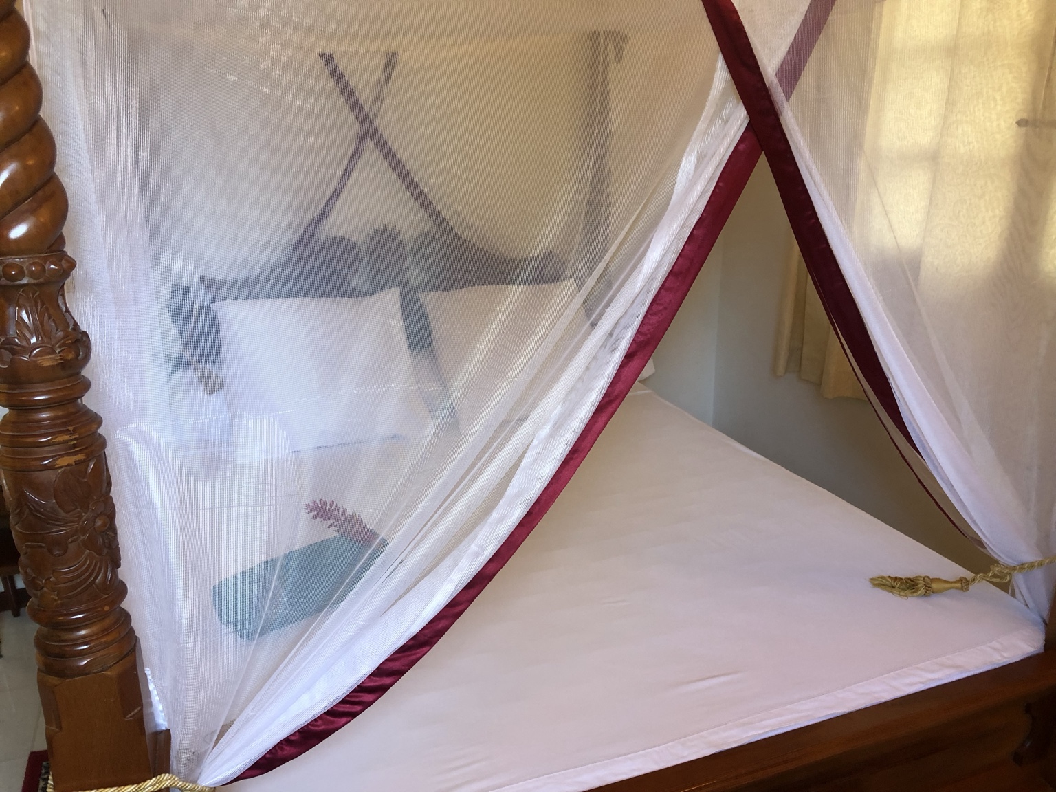 Chambre avec lit à baldaquin et moustiquaire à la Villa Palatium Martinique