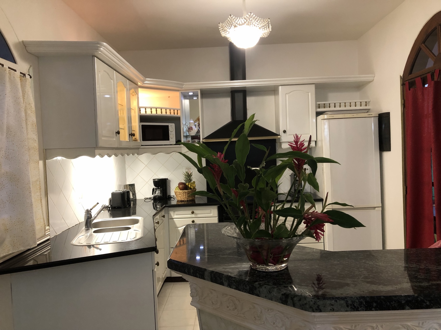 La cuisine des Villas Palatium, avec son comptoir et un bouquet tropical